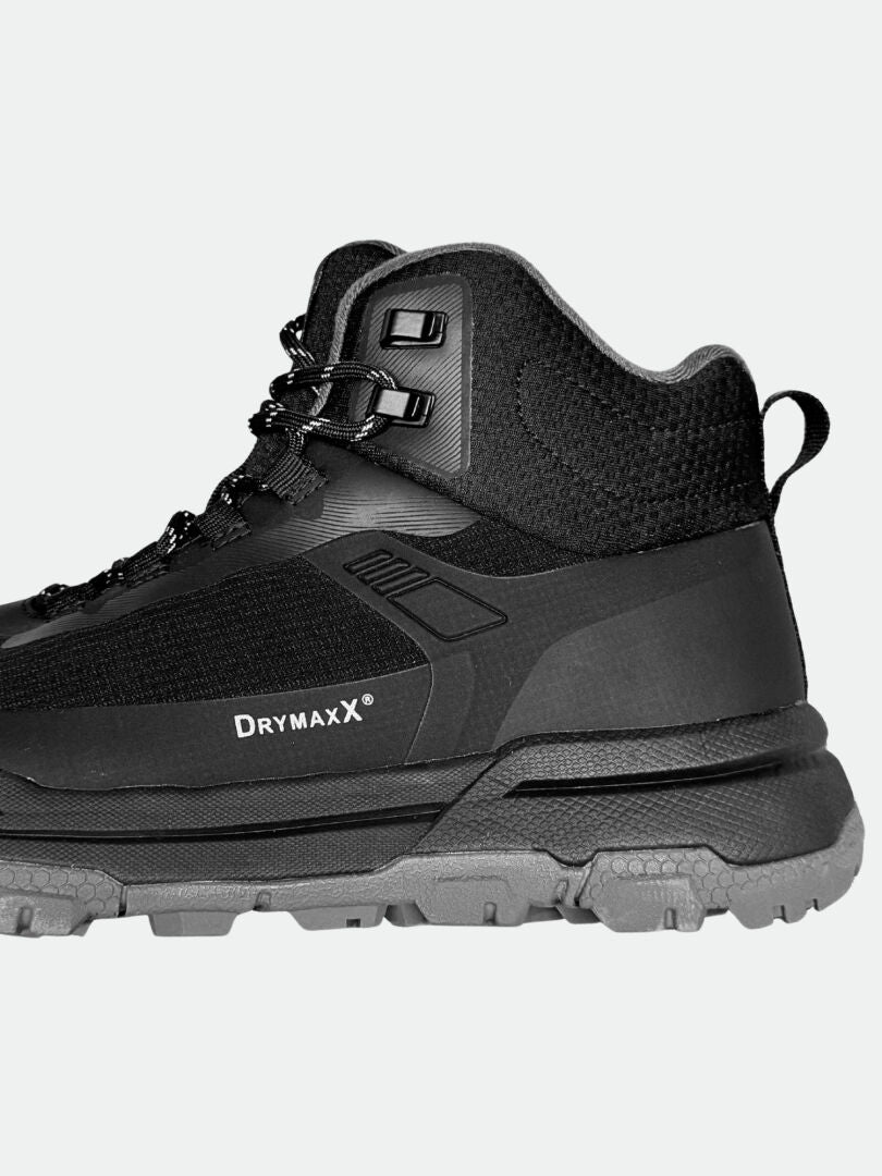 Close-up of Halti Fara 3 DX Mid Mens outdoor shoe in black with rugged grey sole and reliable grip on a plain background.