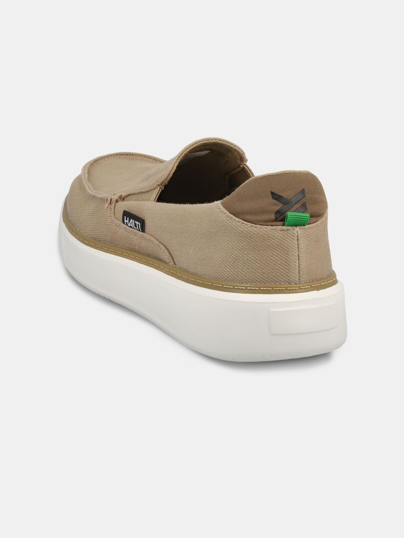 The Halti Lido Canvas Shoe Men's in tan features a white sole and logo tag, shown from the back-left angle.