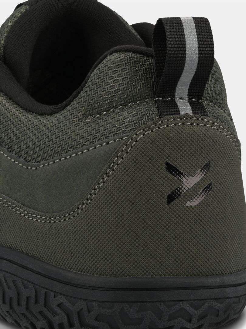 Close-up of the heel of Halti Tuntuma DX Barefoot Shoe Men's—green, zero drop, with black/gray pull tab and rubber sole.
