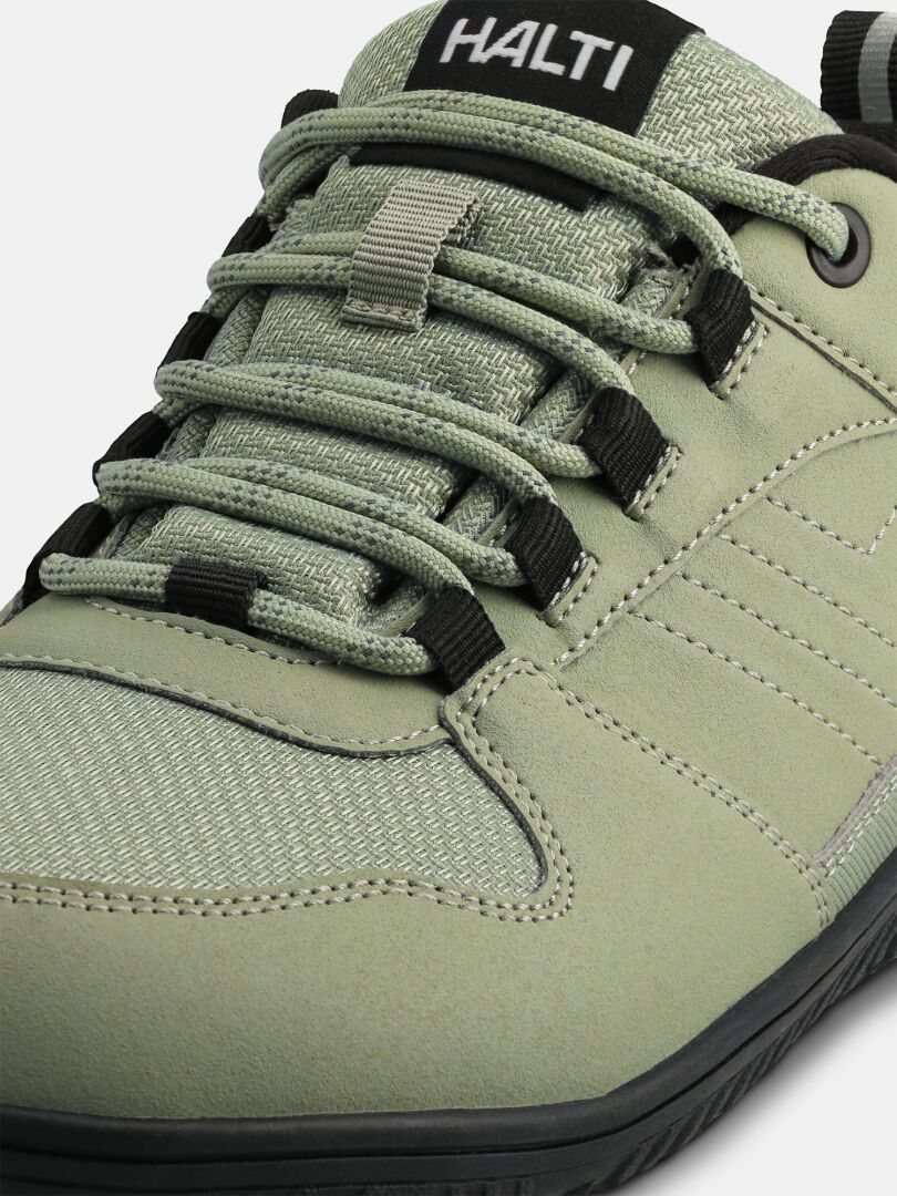 Close-up of a light green Halti Tuntuma DX Barefoot Shoe Women's with black laces and visible stitching details.