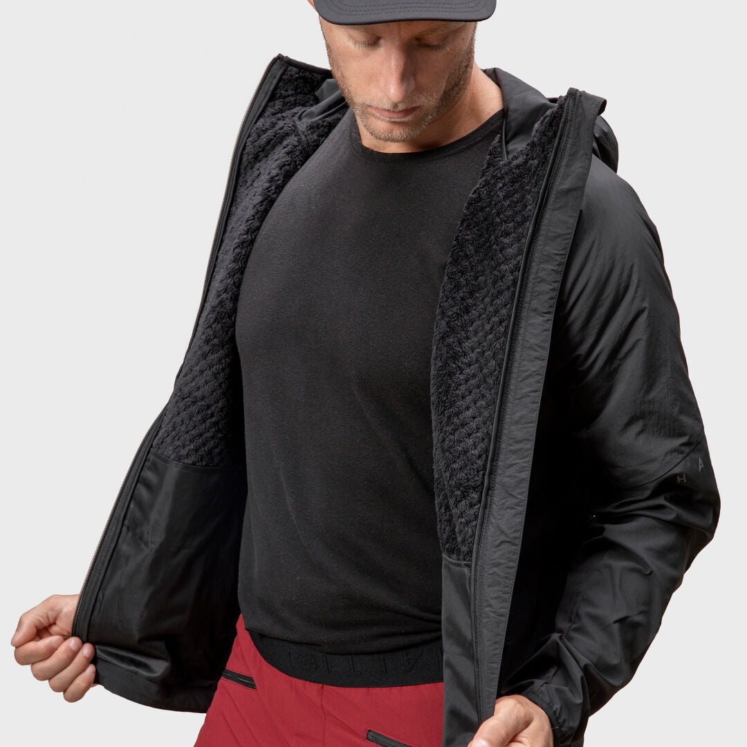 A man in the Halti Crust Mens Layer Jacket displays its inner lining—perfect for winter sports.