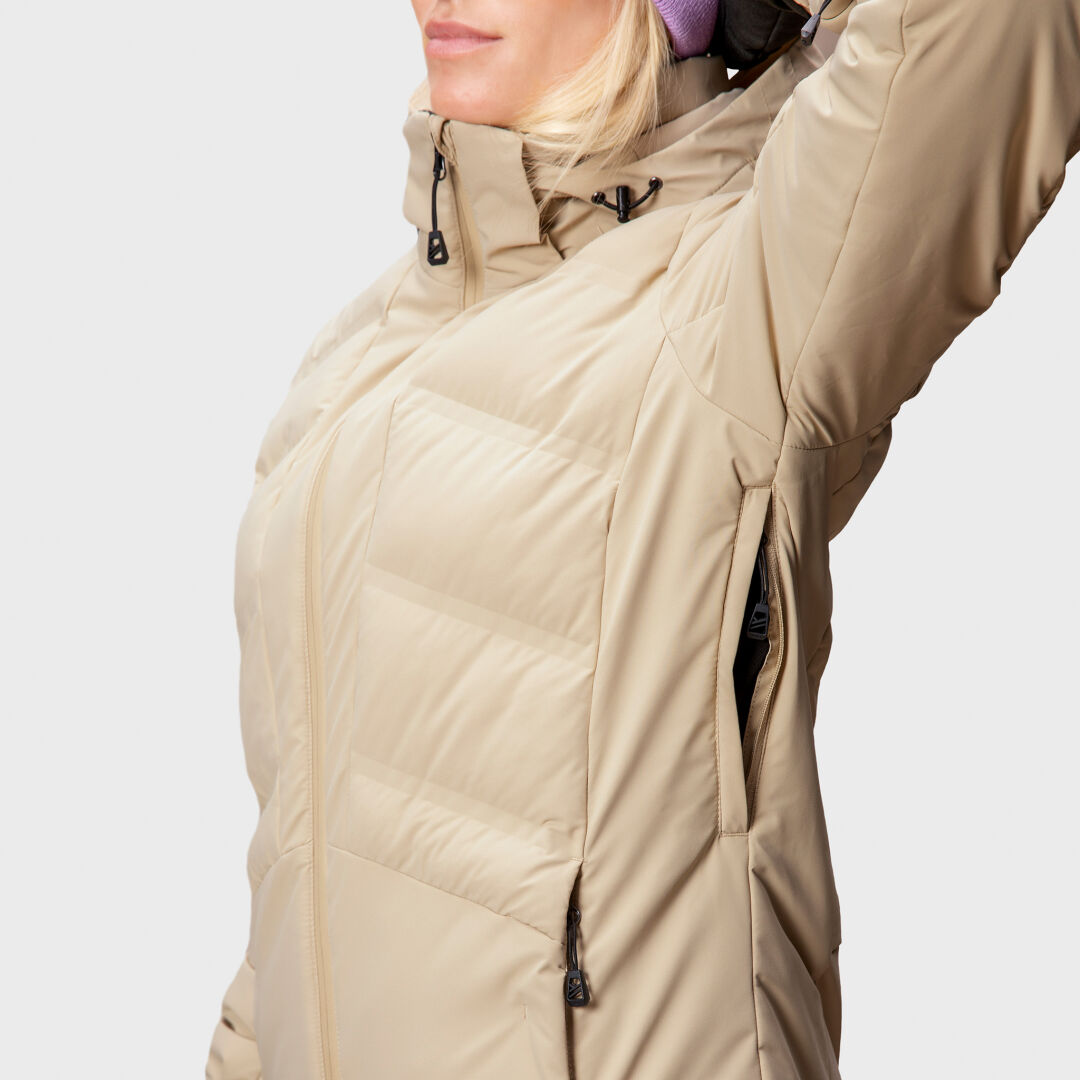 A woman in the Halti Nordic Arcty Ski Jacket raises her arm, showing the underarm ventilation zipper.