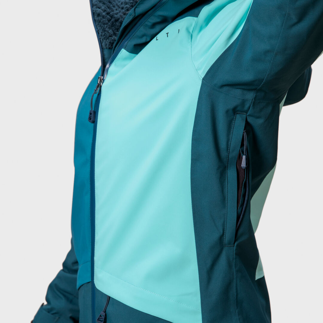 Close-up of Halti Planker DrymaxX Womens Ski Jacket in teal/light blue with waterproof fabric, zip pocket, and textured collar.