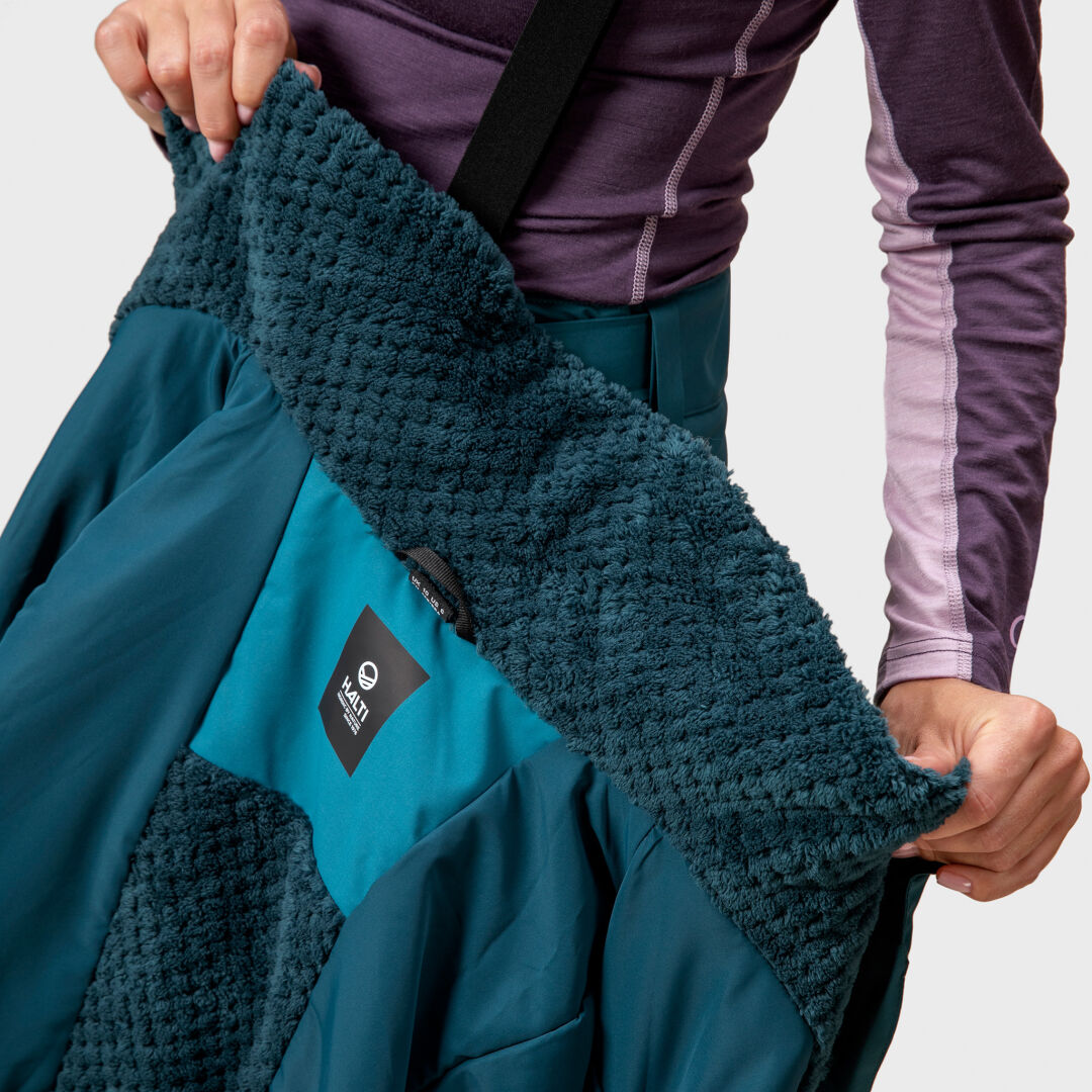 A person holds open the Halti Planker DrymaxX Womens Ski Jacket, wearing a purple long-sleeve shirt.