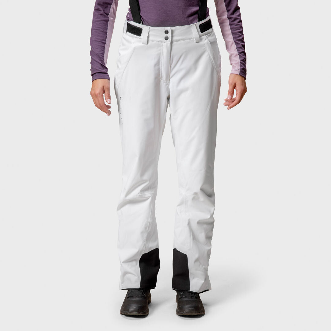 Woman in Halti Trusty DrymaxX Ski Pants, white with black cuff patches, purple shirt, and black boots, facing forward.