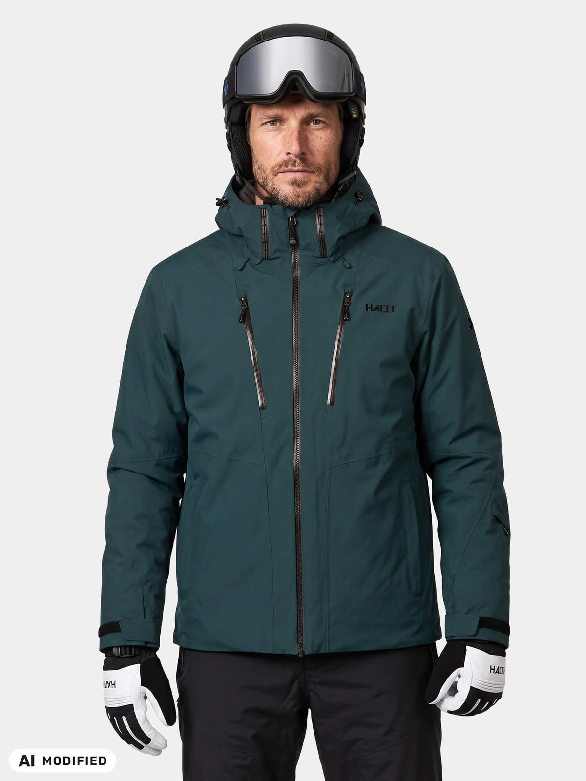 A man wearing a dark green Halti Vertica DX Ski Jacket, black ski pants, and a helmet with goggles.