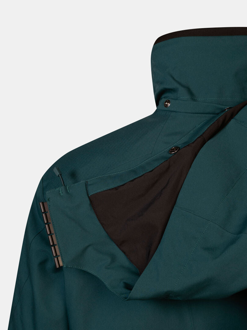 Close-up of a dark teal Halti Vertica DX Ski Jacket Men’s featuring a waterproof fabric and a snap-on detachable hood.