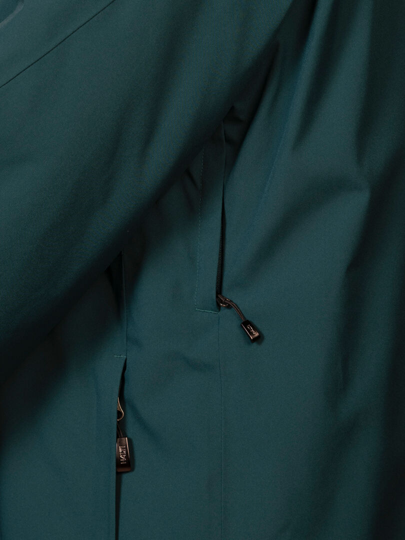 Close-up of a dark teal Halti Vertica DX Ski Jacket Men’s featuring two zippered pockets with black pull tabs.