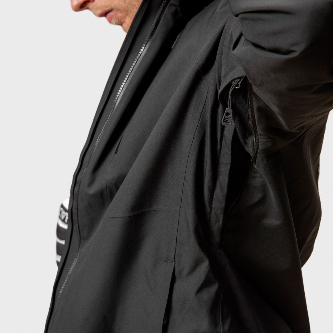 A person wearing a black Halti Vertica DX Ski Jacket Men’s with an open underarm ventilation zipper.