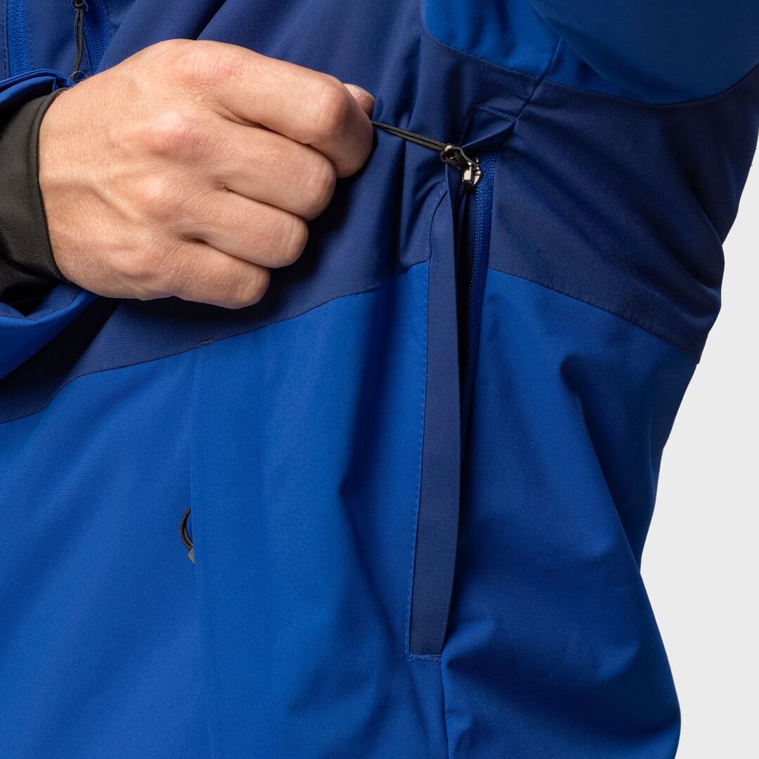 A person adjusts the side pocket drawstring on a Halti Wedeln DrymaxX mens ski jacket in blue.