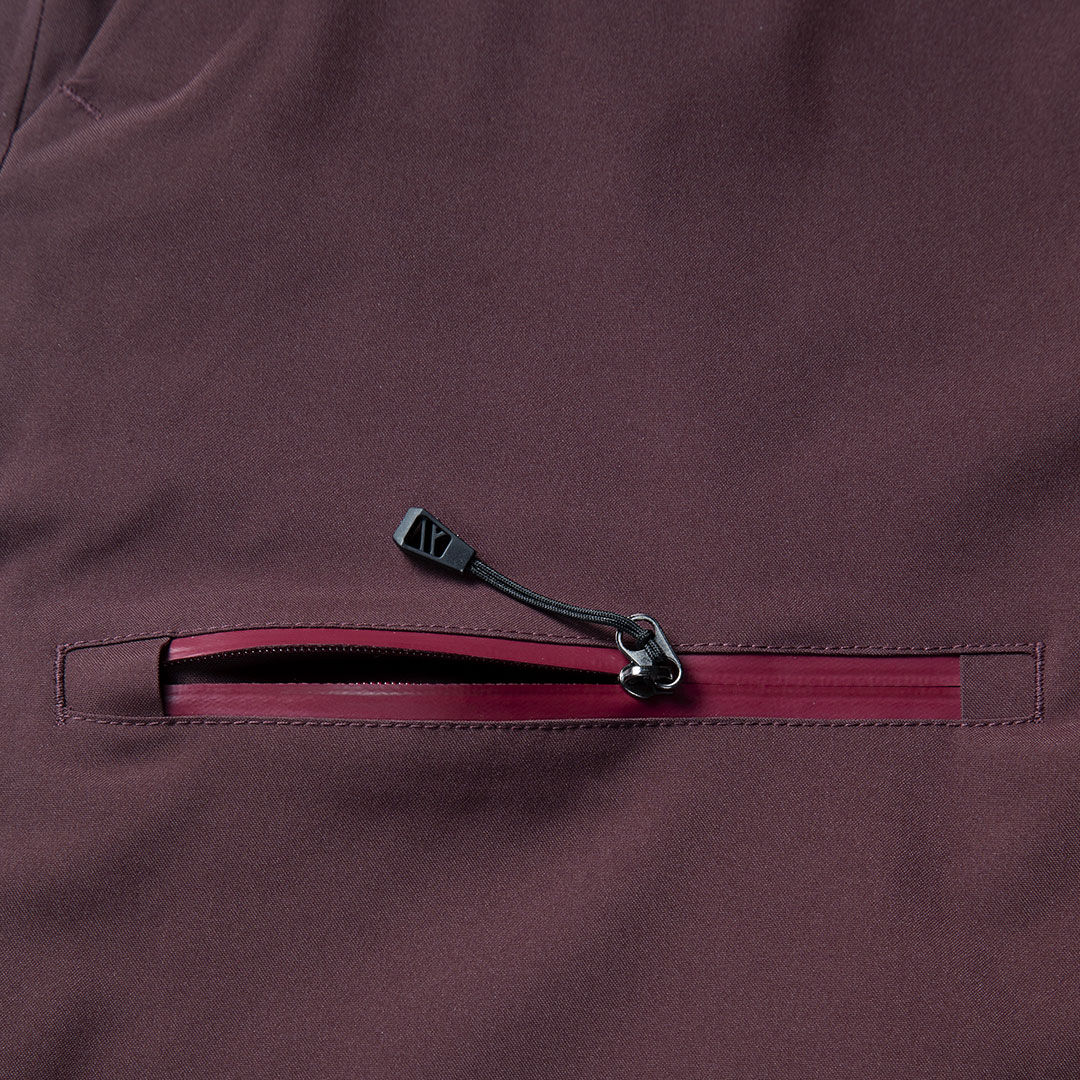 Close-up of a zippered pocket on Halti Carvey DX Ski Pants Men’s, maroon and waterproof with black zipper pull.