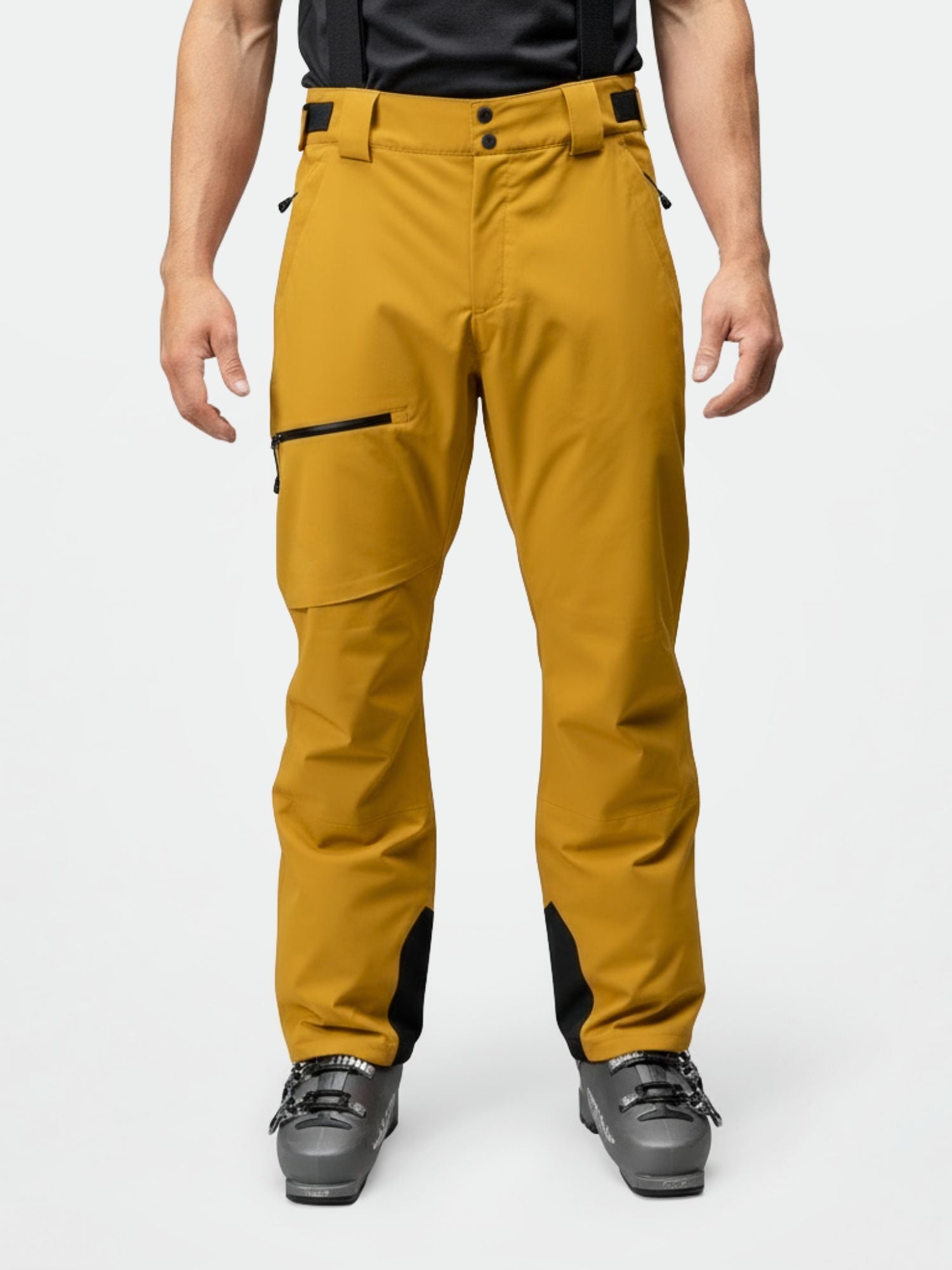 A man wears Halti Carvey DrymaxX mustard yellow ski pants with black accents and ski boots, ready for winter.