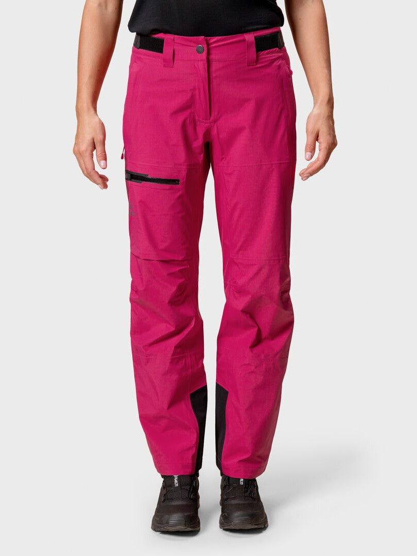 A person in Halti Alpine 3L DrymaxX Shell Pants for women, black shoes, and a black top stands against a light background.