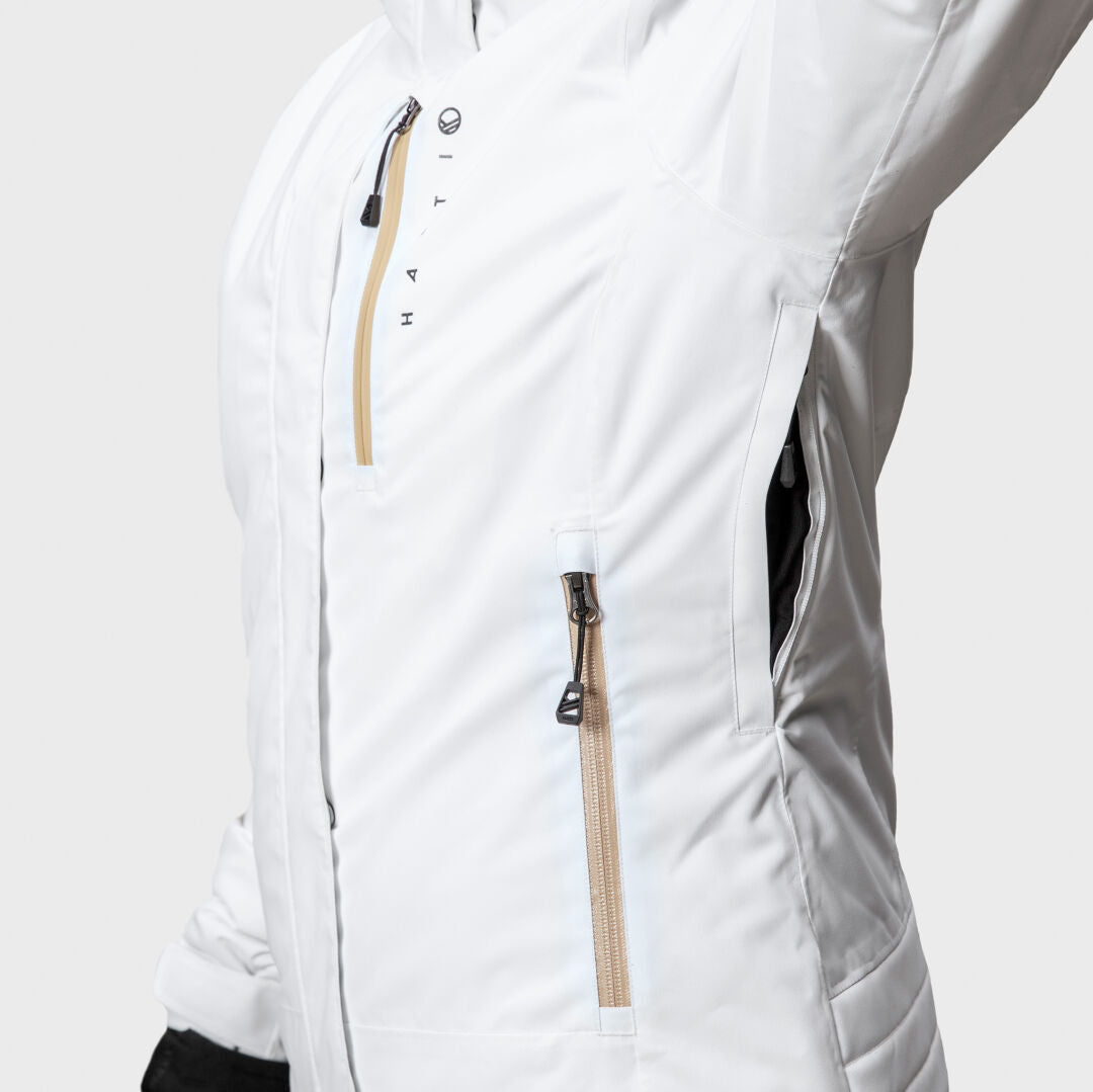 Close-up of Halti Radius DX Women's Ski Jacket in white, featuring beige zippers, chest pocket, and side zip pocket.