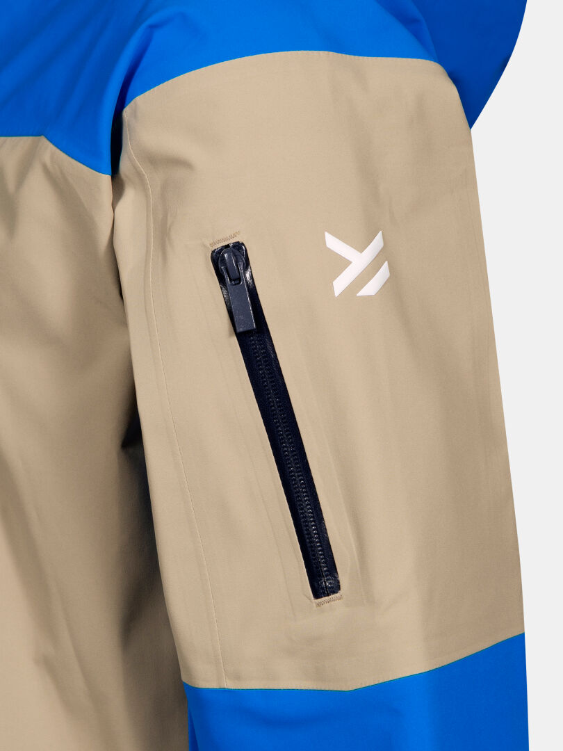 Close-up of the Halti Rizle 3L DX Ski Jacket sleeve with black zip pocket and white geometric logo above.