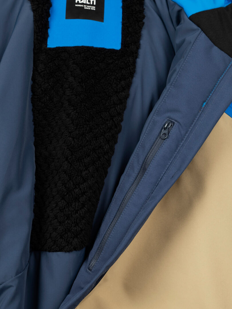 Close-up of Halti Melvik Dx Ski Jacket Men's interior with blue, tan, and black fleece lining and a zippered pocket.