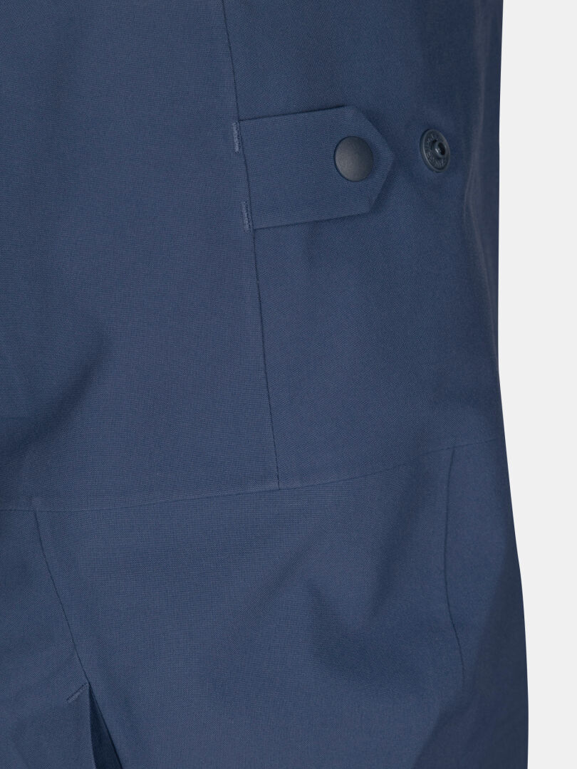 Close-up of navy blue Rizle 3L Dx Ski Pants featuring an adjustable waist tab with a snap button.