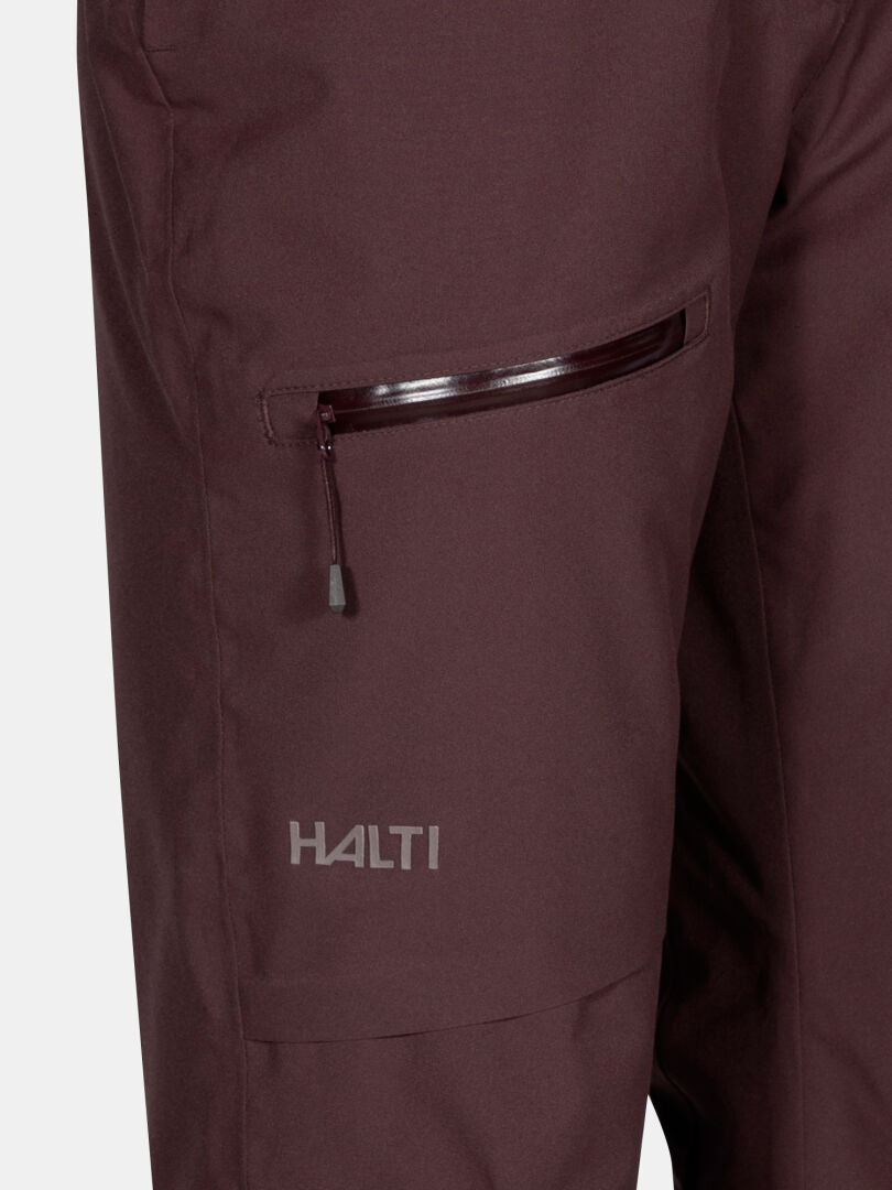 Close-up of Halti Carvey II DX Women's maroon ski pants with a zip pocket and logo on the left thigh.