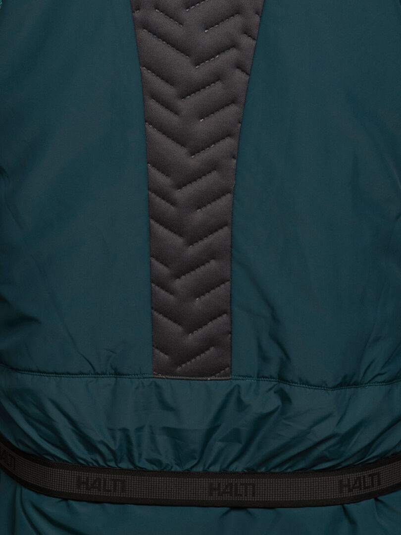 Close-up of a teal Halti Varion 2in1 DX Ski Jacket Women’s with a grey chevron-quilted panel and an elasticized waistband.
