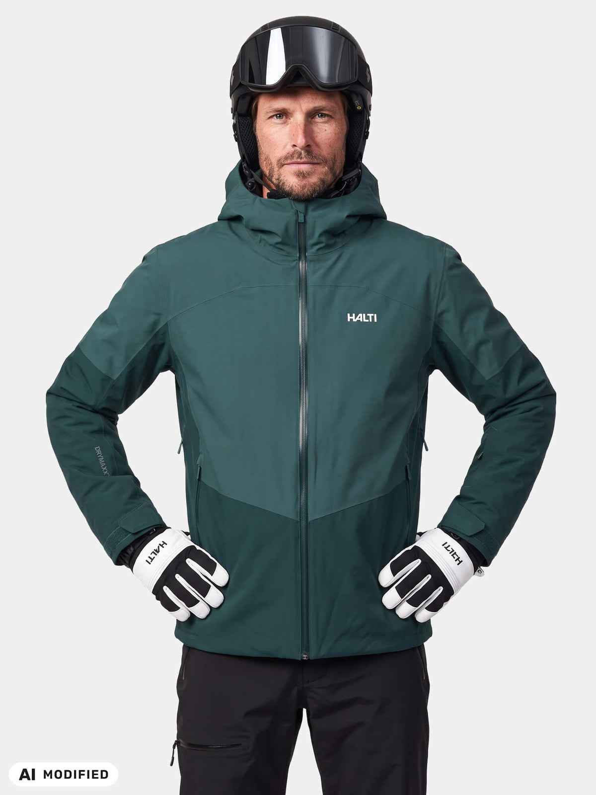 A man in a dark green Halti Melvik II DX Ski Jacket, black helmet with goggles, and white and black gloves.
