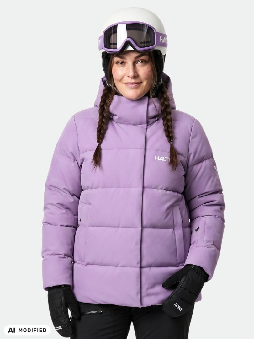 A woman wearing a lavender Halti Ascloud Puffer Ski Jacket Women’s Plus, helmet, and goggles.