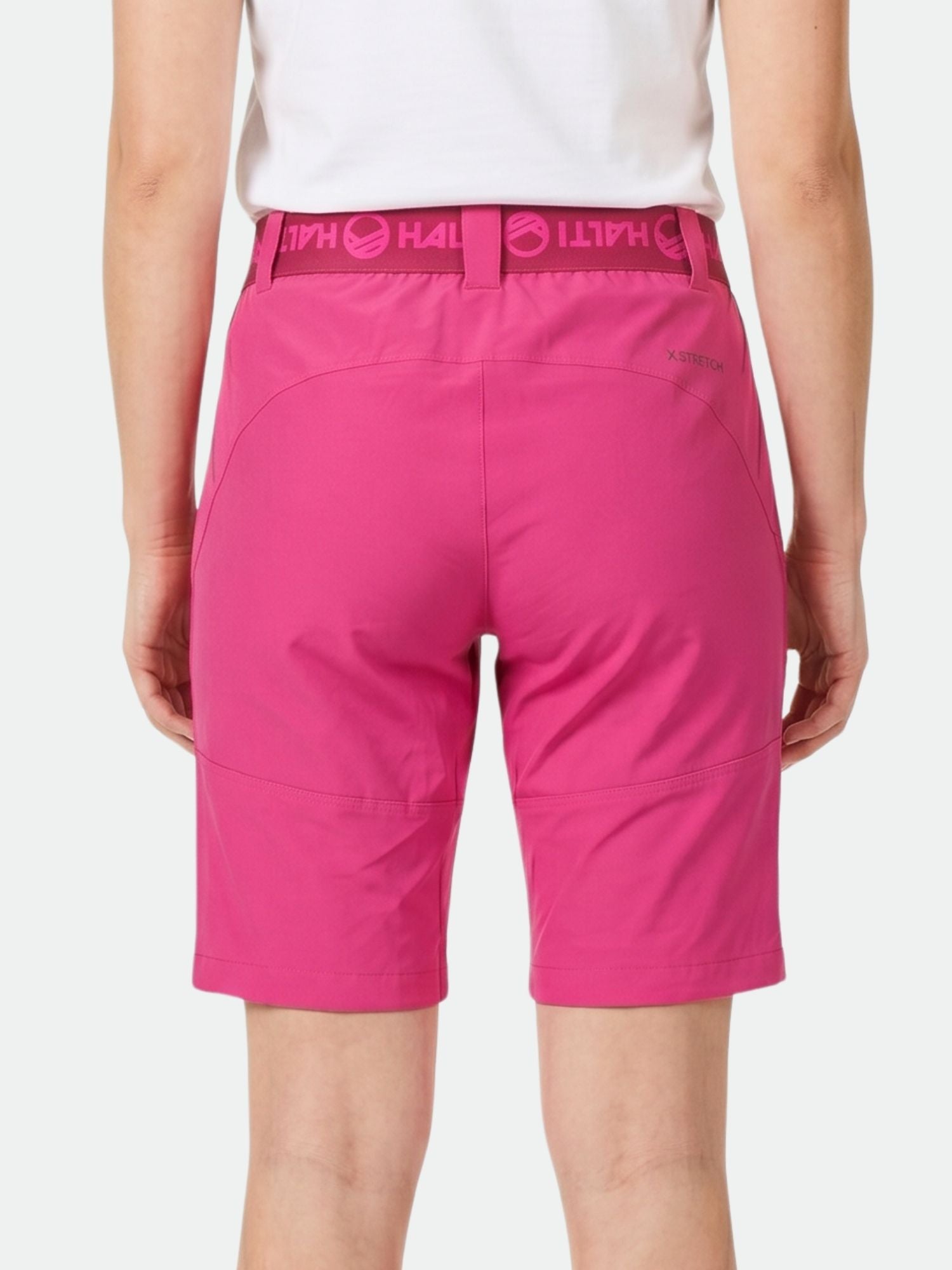 A person wears Halti Pallas Women's X-stretch Lite Shorts in bright pink and a white shirt, seen from the back.