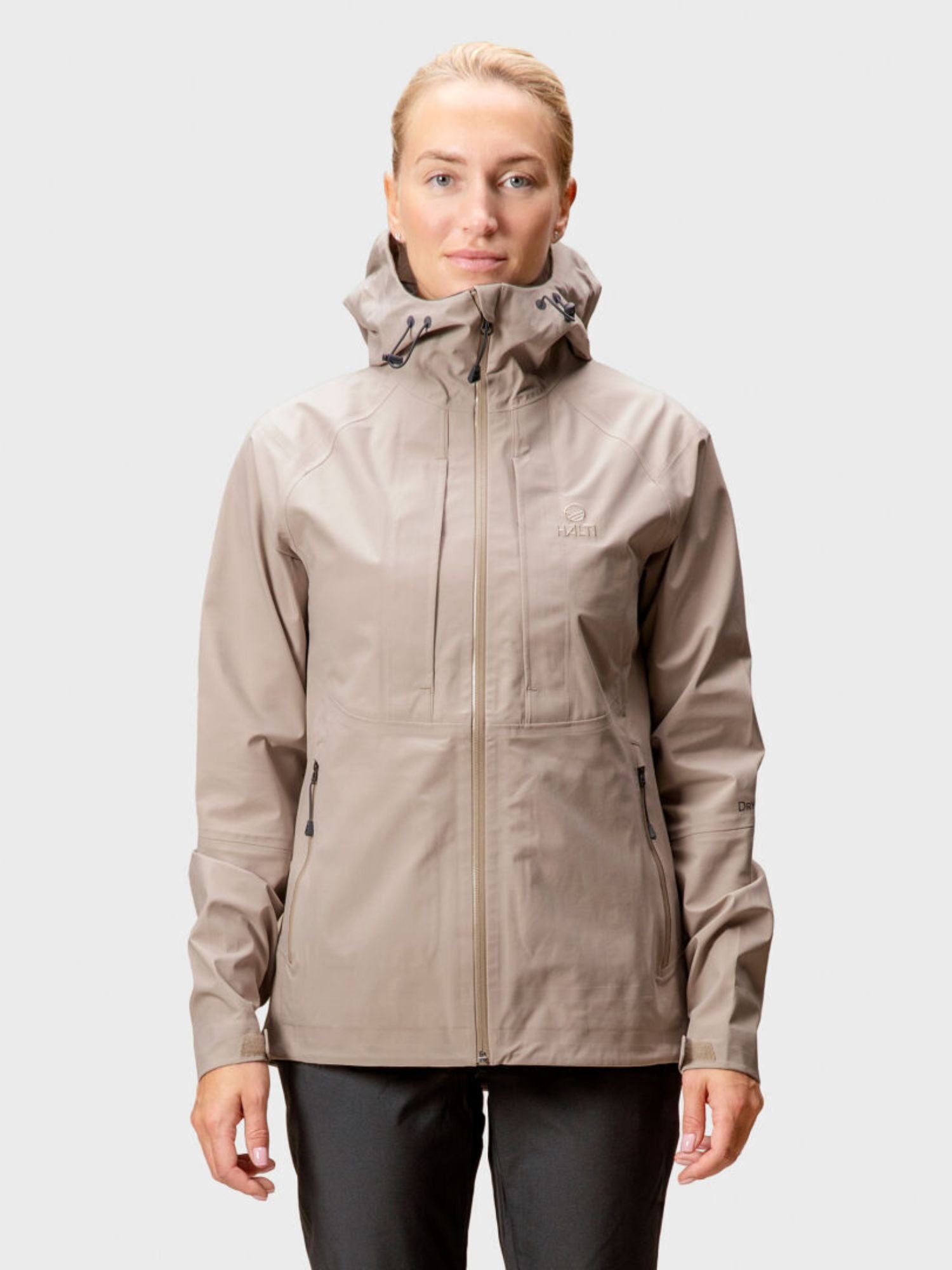 A woman wears the Halti Kaarna Womens DX 3L Shell Jacket, facing forward against a plain light gray background.