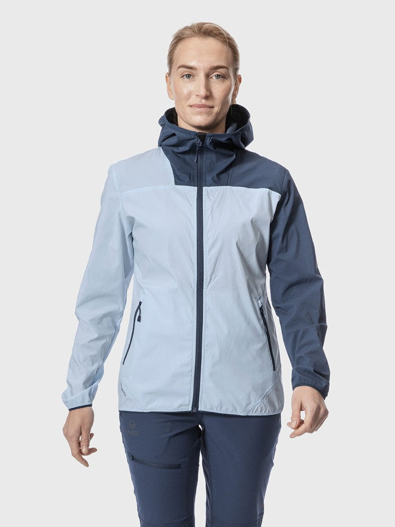 A person wears the Halti Pallas Womens Lite X-stretch jacket in light blue and navy, standing against a plain background.