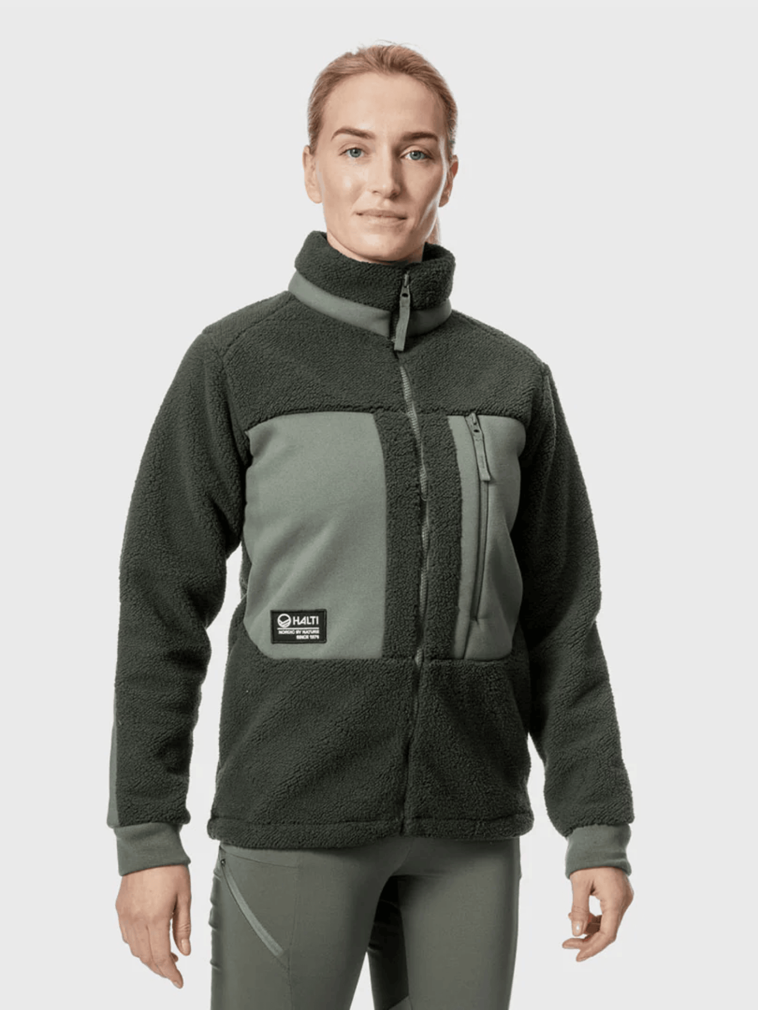 A person wears the Halti Hiker Womens Polar Fleece Jacket and matching pants, standing against a plain background.