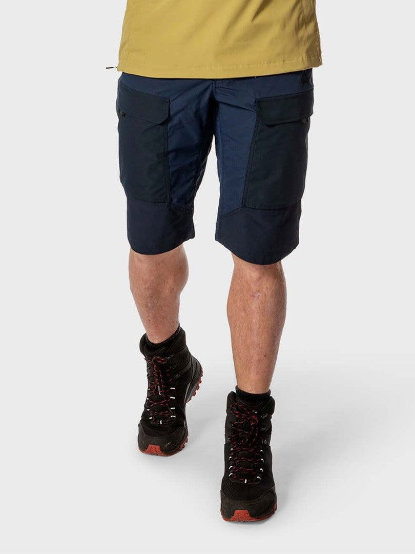 Person wearing a yellow shirt and Halti Hiker Mens Lite Shorts in navy, paired with black boots against a plain background.