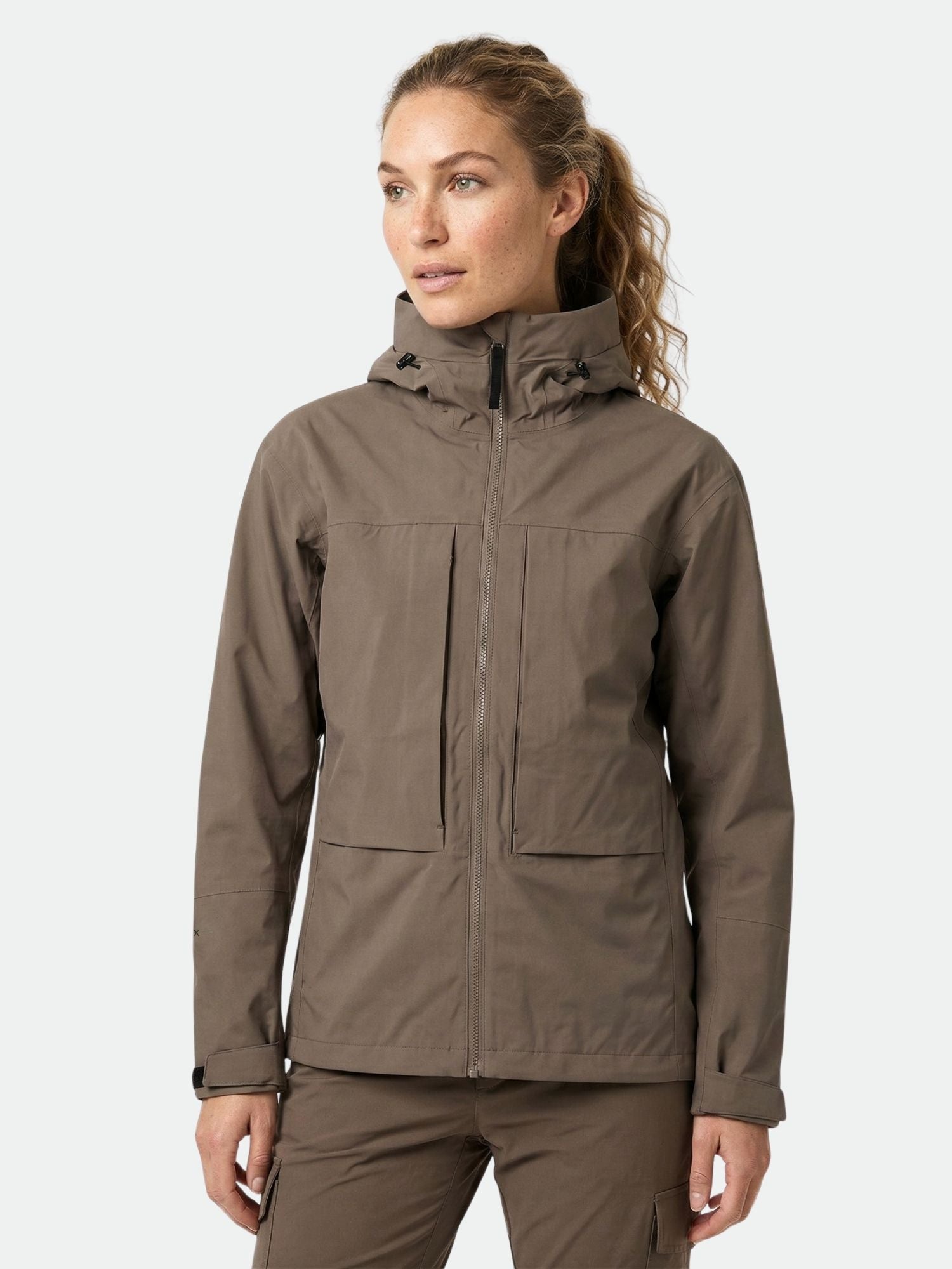 A woman wears the Halti Hiker II DrymaxX Shell Jacket in brown, standing against a plain light background.
