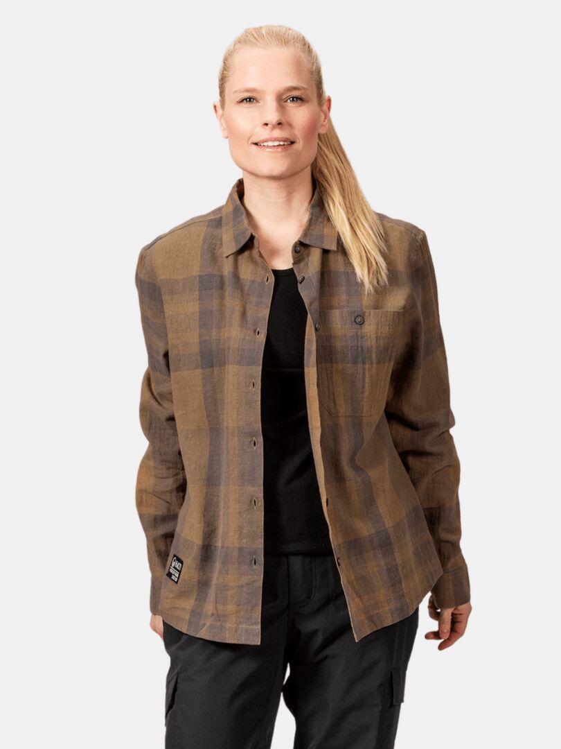 Woman in Halti Hiker Trekking Shirt, brown and black, over black pants, standing and smiling.