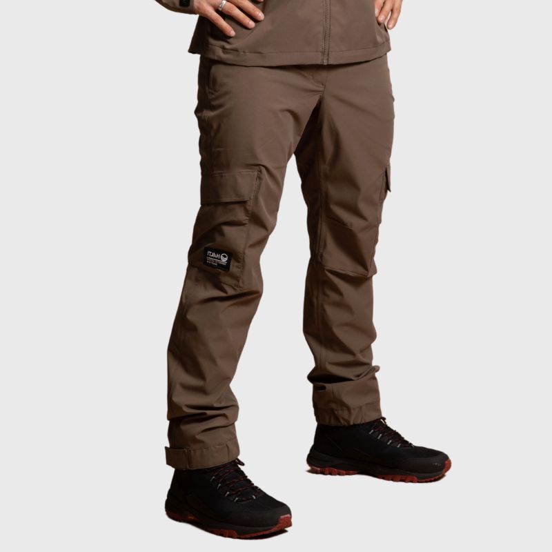 Man wearing Halti Hiker II DrymaxX Shell Pants and black athletic shoes, standing against a light gray background.