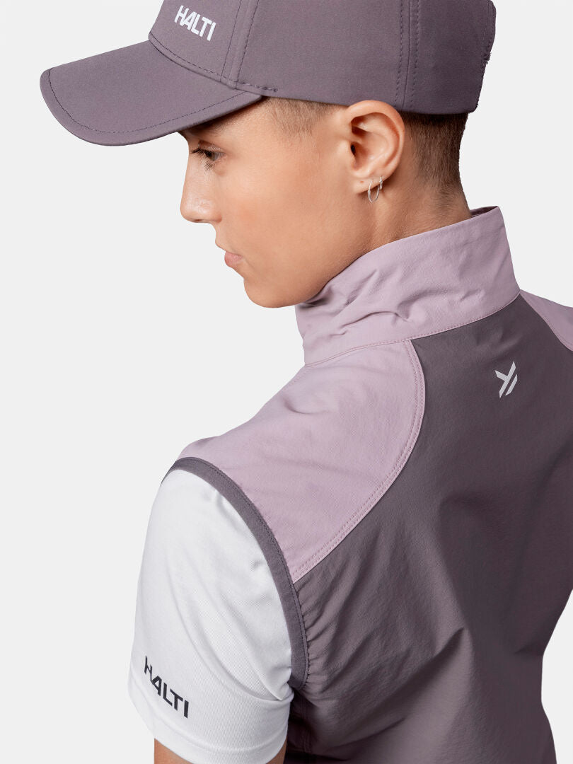 Person wearing a gray Halti cap, a purple and white Halti jacket, and a Halti Pallas Evo X-stretch Vest, facing away.