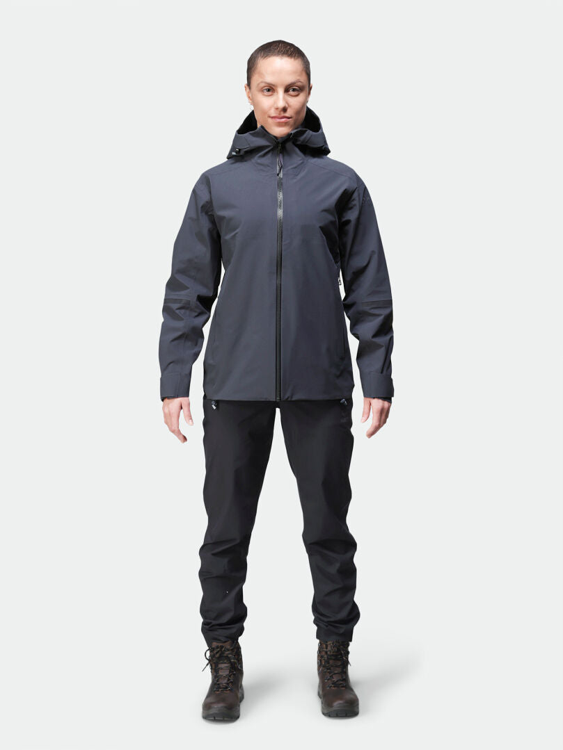 A woman faces forward wearing the Halti Kajana 3L DX Shell Jacket, paired with matching pants and hiking boots.