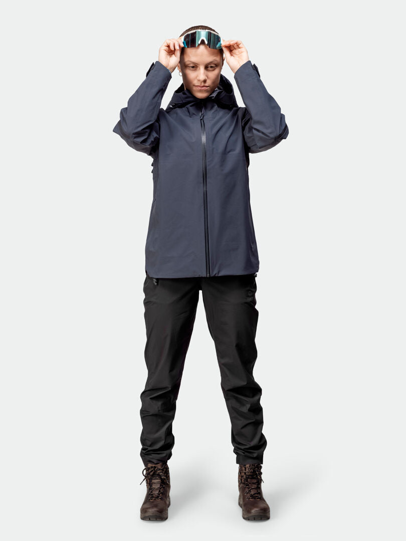 Wearing the Halti Kajana 3L DX Shell Jacket Womens, a person adjusts ski goggles—ideal for outdoor adventures.