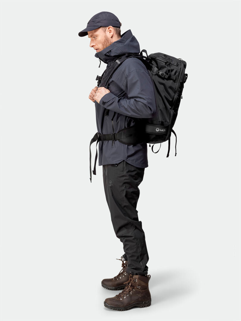 Man in Halti Kajana 3L DX Shell Jacket stands in profile—perfect for outdoor enthusiasts seeking lightweight comfort.