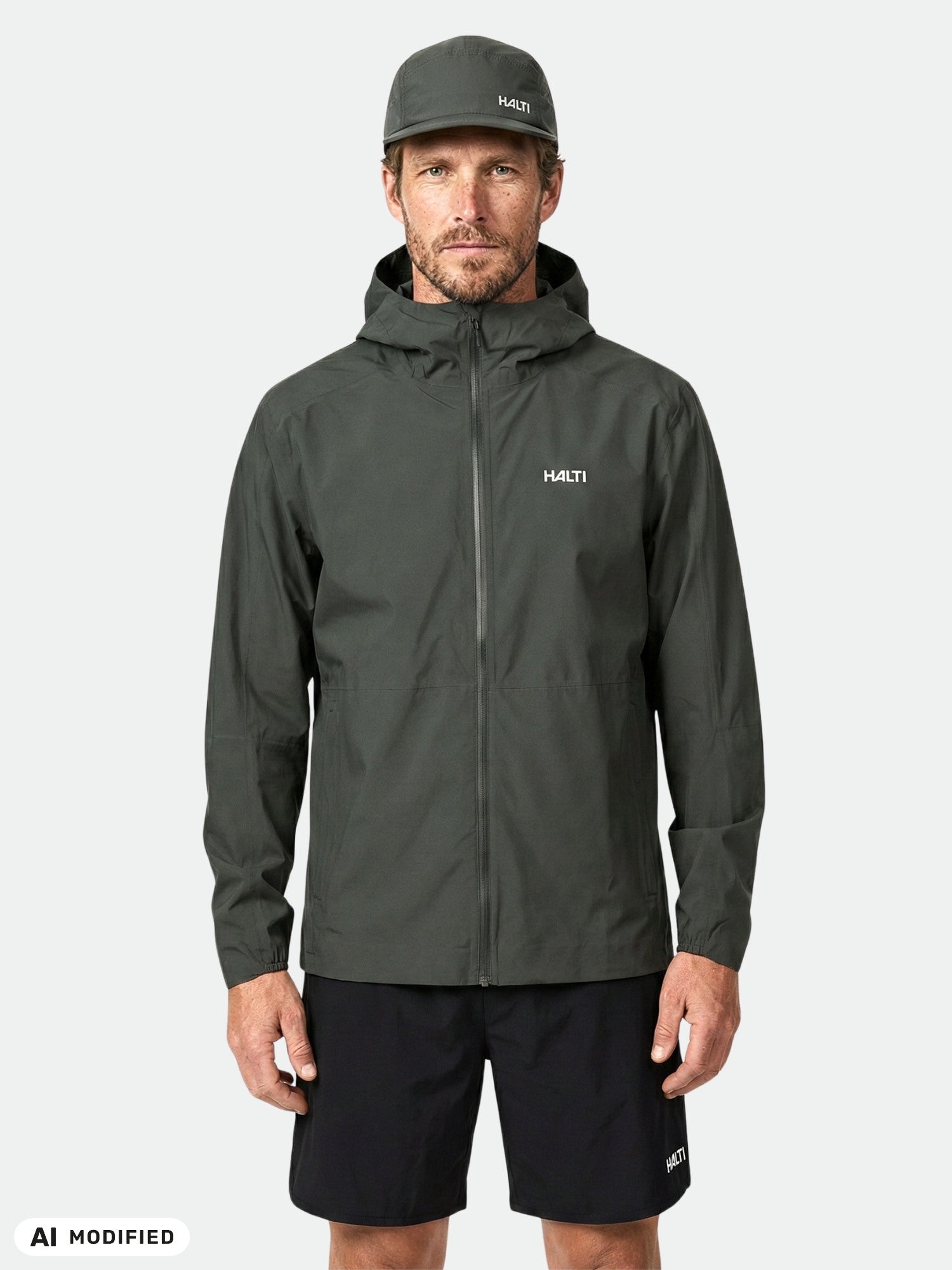 Man in Halti Pisarat 2,5L DX Shell Jacket and matching cap faces forward against plain background.