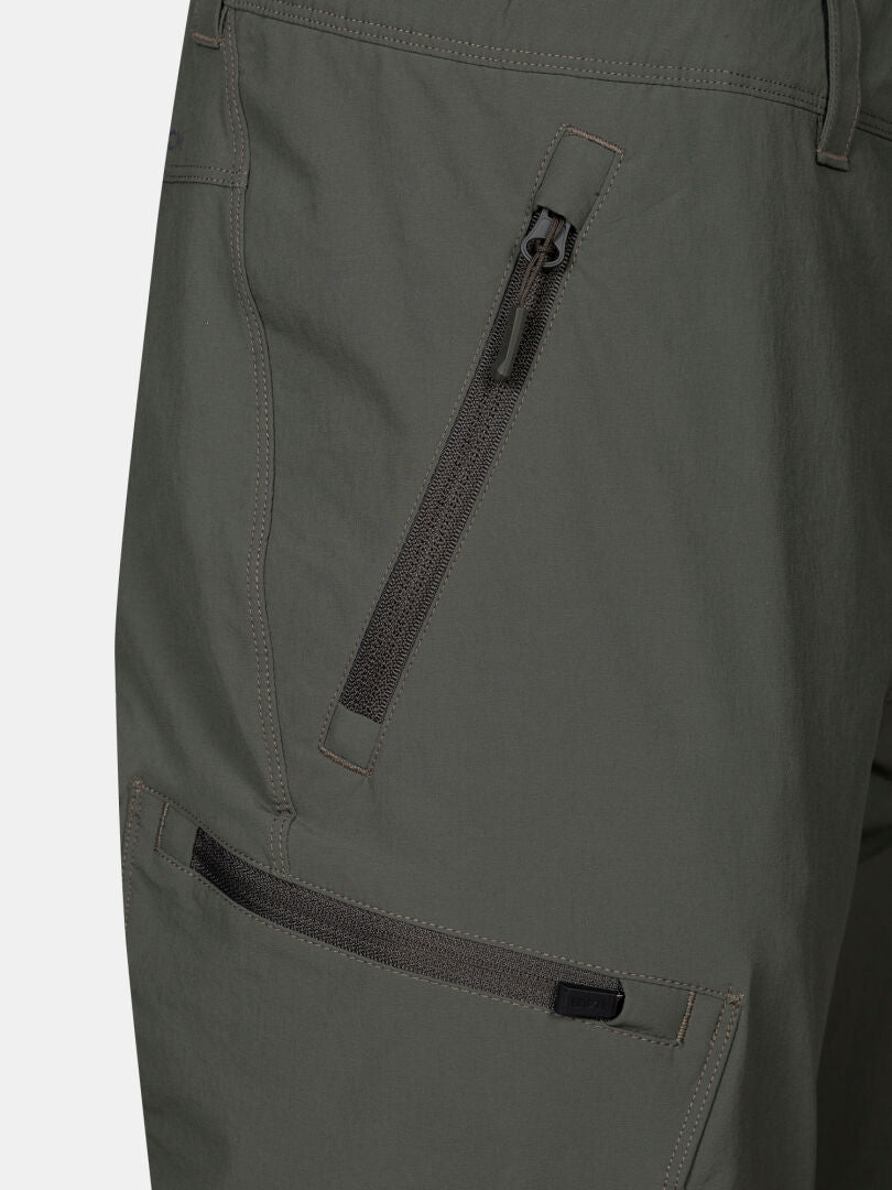 Close-up of Halti Pallas Evo Plus X-stretch women's green pants with two zippered pockets and visible stitching.