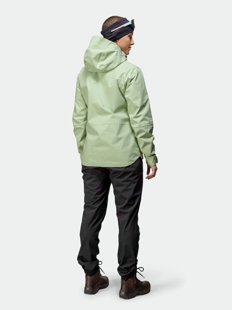 Person facing away, wearing Halti Staala DrymaxX Shell Jacket Womens (light green), black pants, boots, and headband.