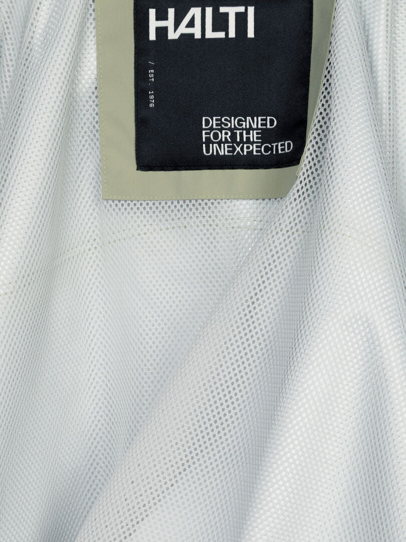 Close-up of a Halti Staala DX Shell Jacket Women’s label reading DESIGNED FOR THE UNEXPECTED on water-repellent fabric.