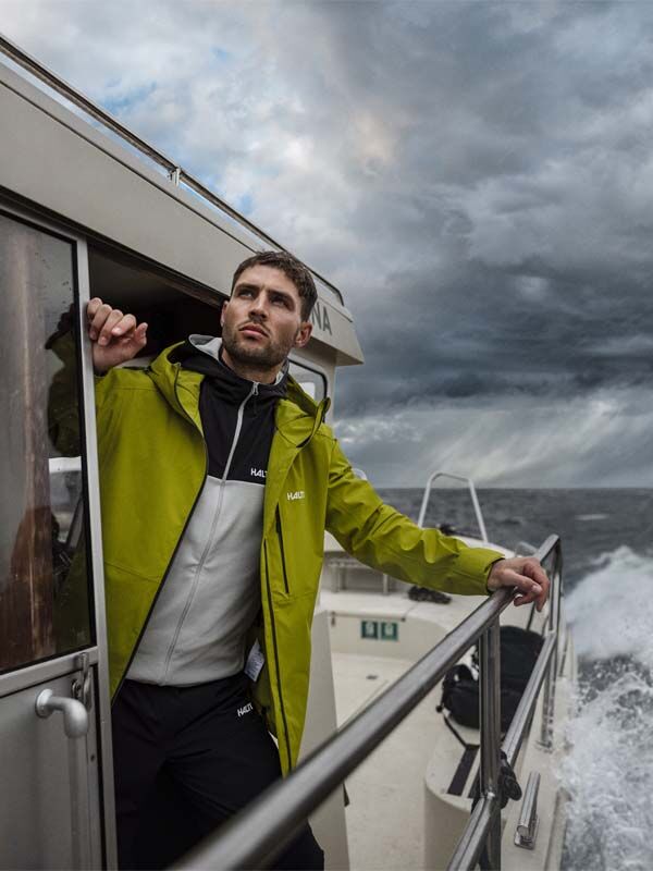A man wearing the Halti Staala DX Shell Jacket stands on a boat.