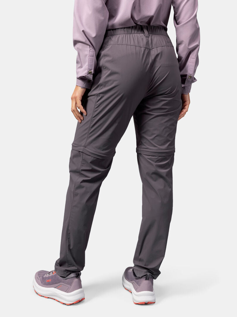 Woman shown from the back wearing Halti Pallas Cool Stretch Zip-off Pants, lavender shirt, and gray sneakers.