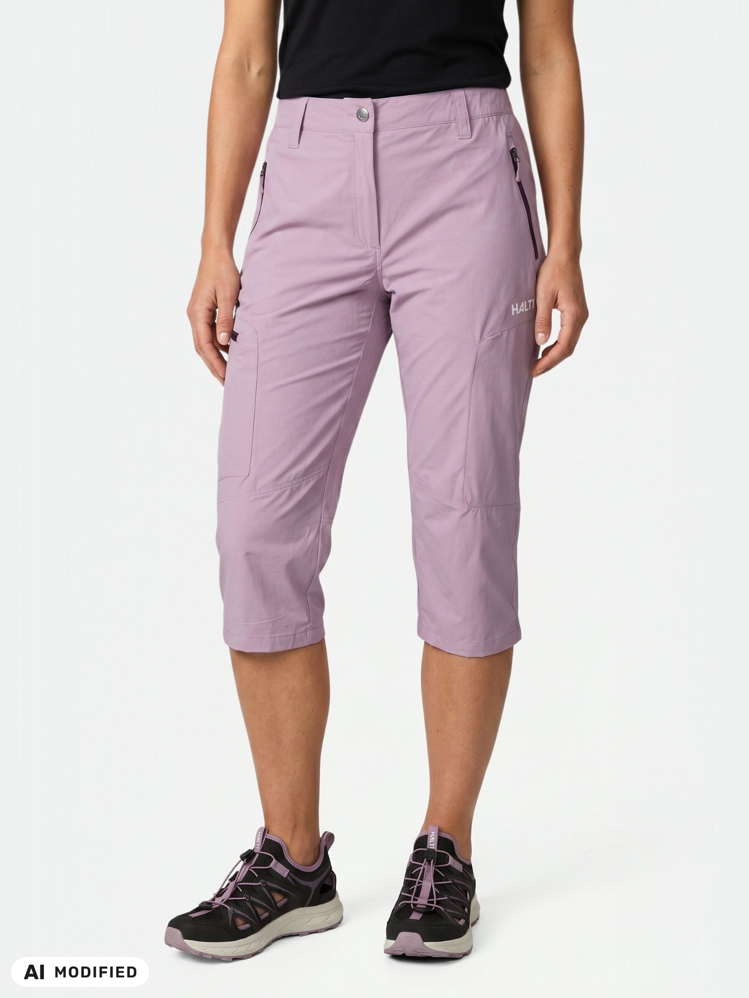 Woman in Halti Pallas Cool X-stretch capri pants, black tee, and athletic shoes.