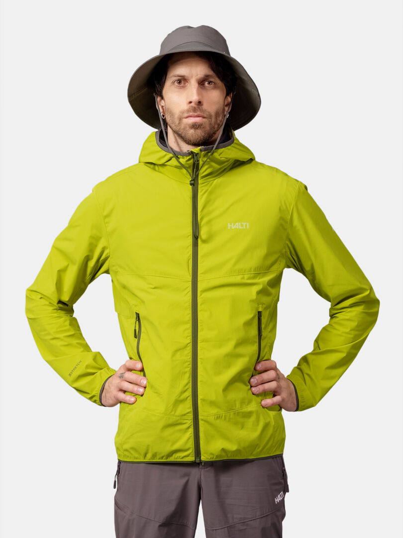 A man wearing the Halti Pallas Cool X-stretch Jacket and a gray wide-brim hat stands with hands on hips against white.