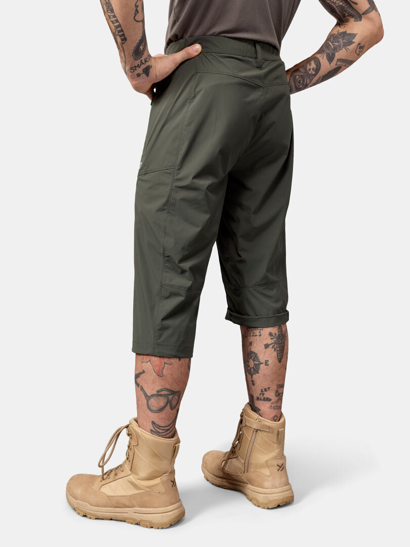 Person in Halti Pallas Cool X-stretch capri pants, tan boots, gray shirt; tattoos visible on legs and arms.