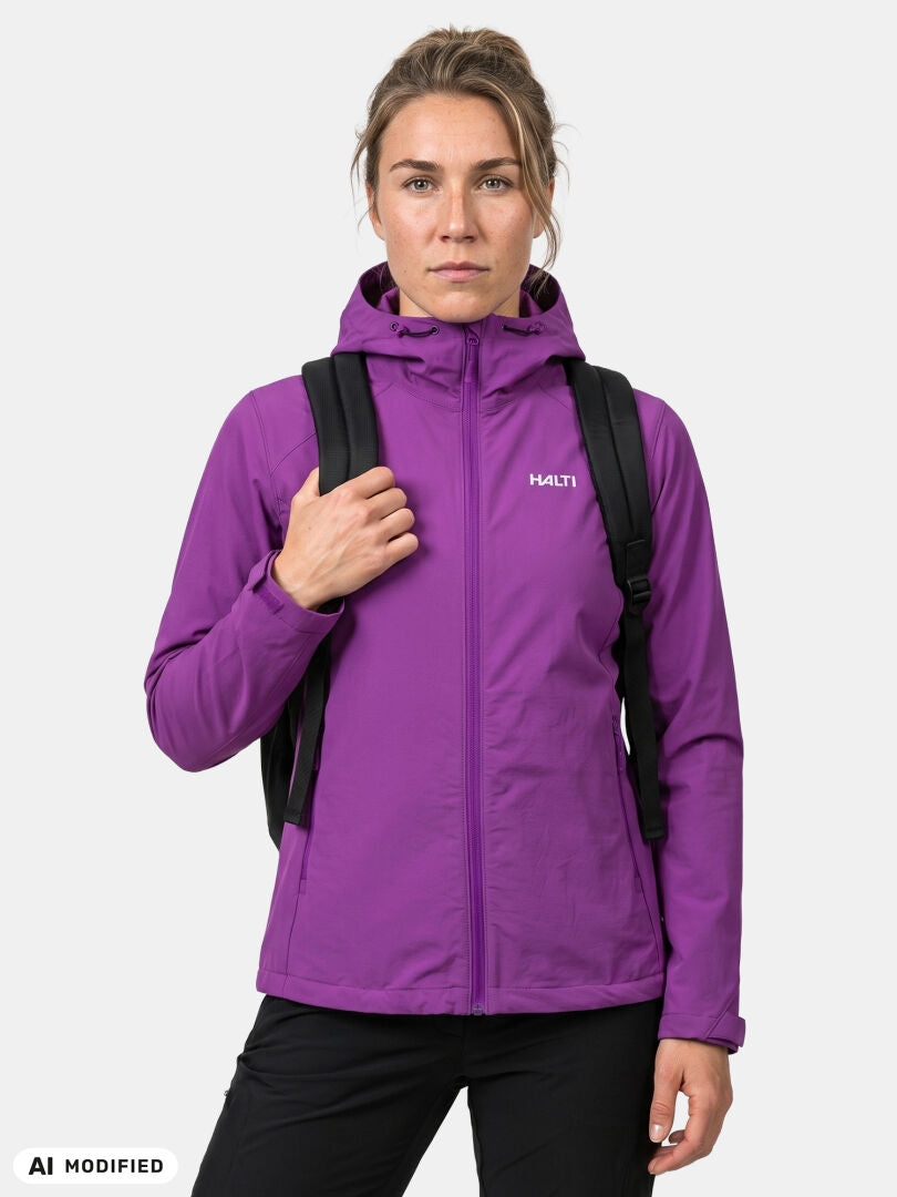 Model in Halti Finholma X-stretch women’s purple jacket with windproof stretch, black backpack, on white background.