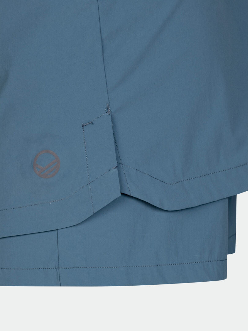 Close-up of Halti Pallas Cool Skort Women's blue moisture-wicking fabric, detailed stitching, and logo near the hem.