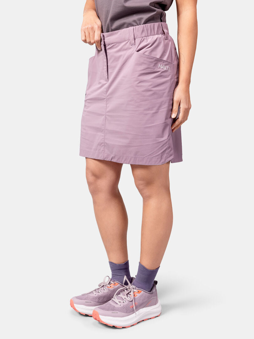A person in Halti’s Pallas Cool Skort Women’s, purple socks, and sneakers, featuring quick-drying fabric.