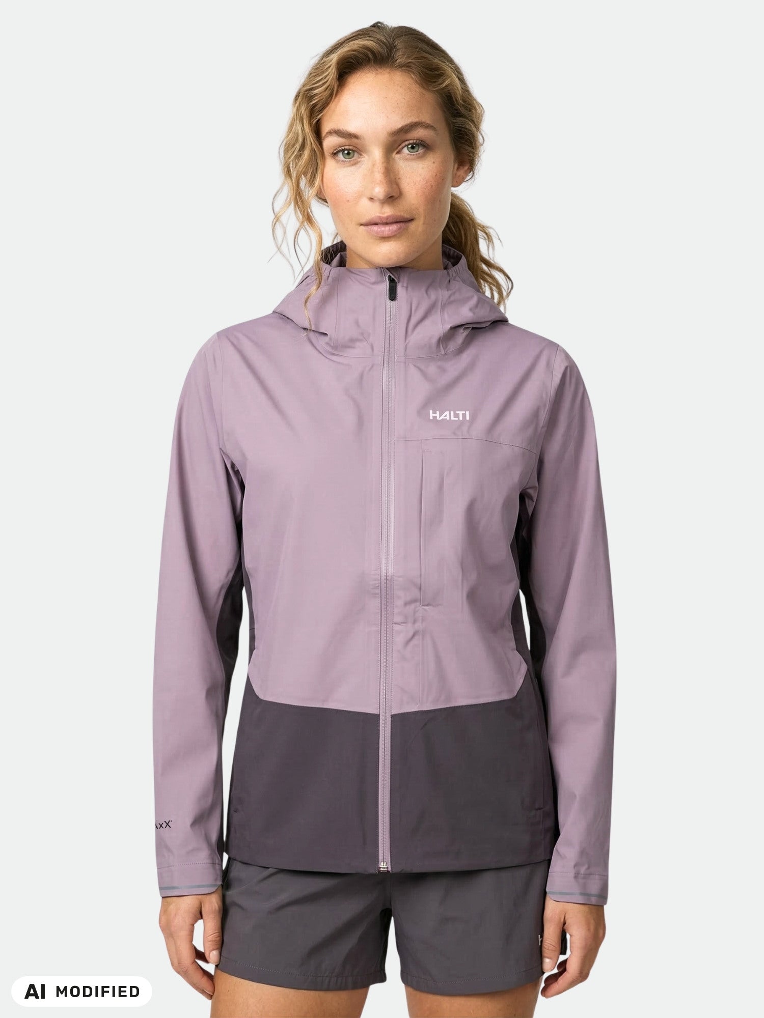 Woman in Halti Taival DX 3L Jacket, light purple/dark gray, standing against a plain light background.
